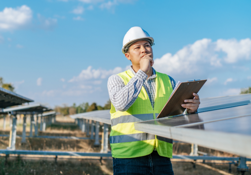 young-asian-inspector-engineer-man-working-solar-farm-technician-supervisor-male-white-helmet-checking-operation-sun-photovoltaic-solar-panel-station-copy-space 1